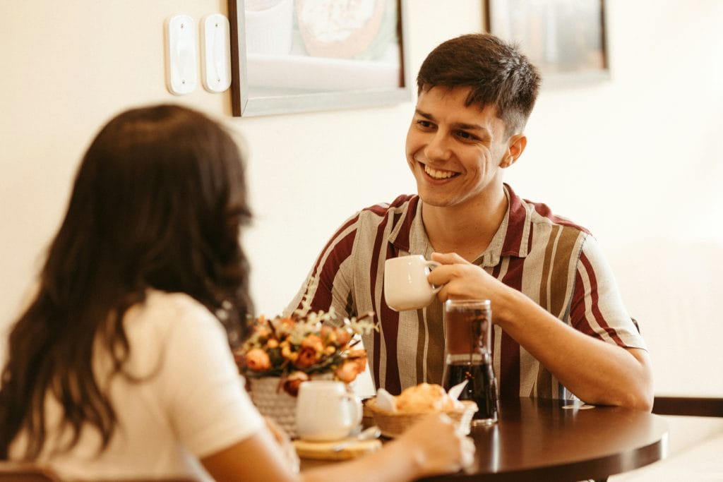 Couple talking and laughing over coffee, the kind of easy conversation speed dating Vancouver events are built around