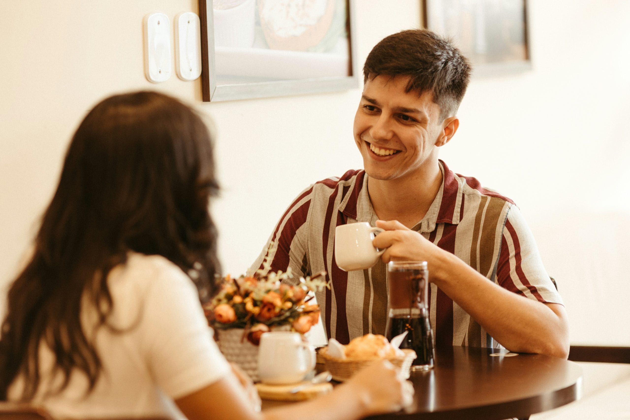 Couple talking and laughing over coffee, the kind of easy conversation speed dating Vancouver events are built around