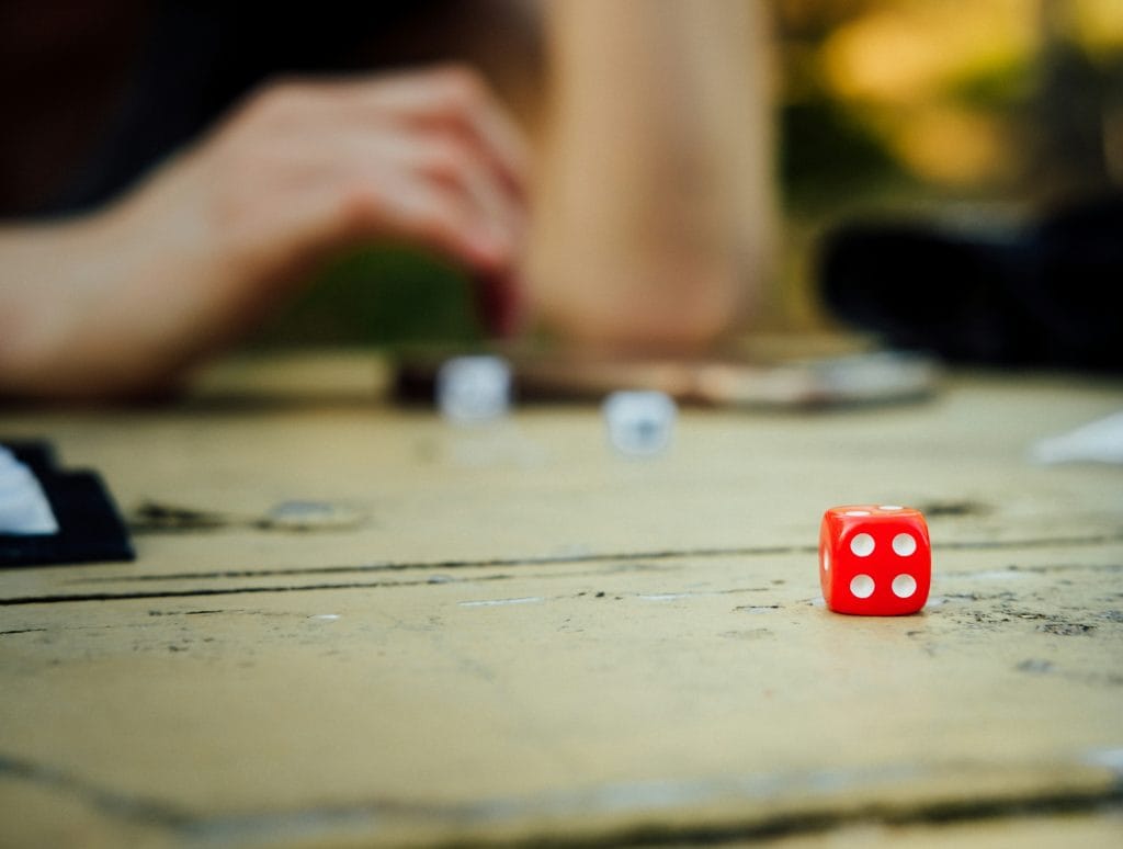 Red die on a wooden table mid-game, the relaxed setup of a trivia night Vancouver locals enjoy each week